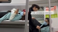 大妈横躺地铁玩手机 被小伙“脱衣盖被”视频热传